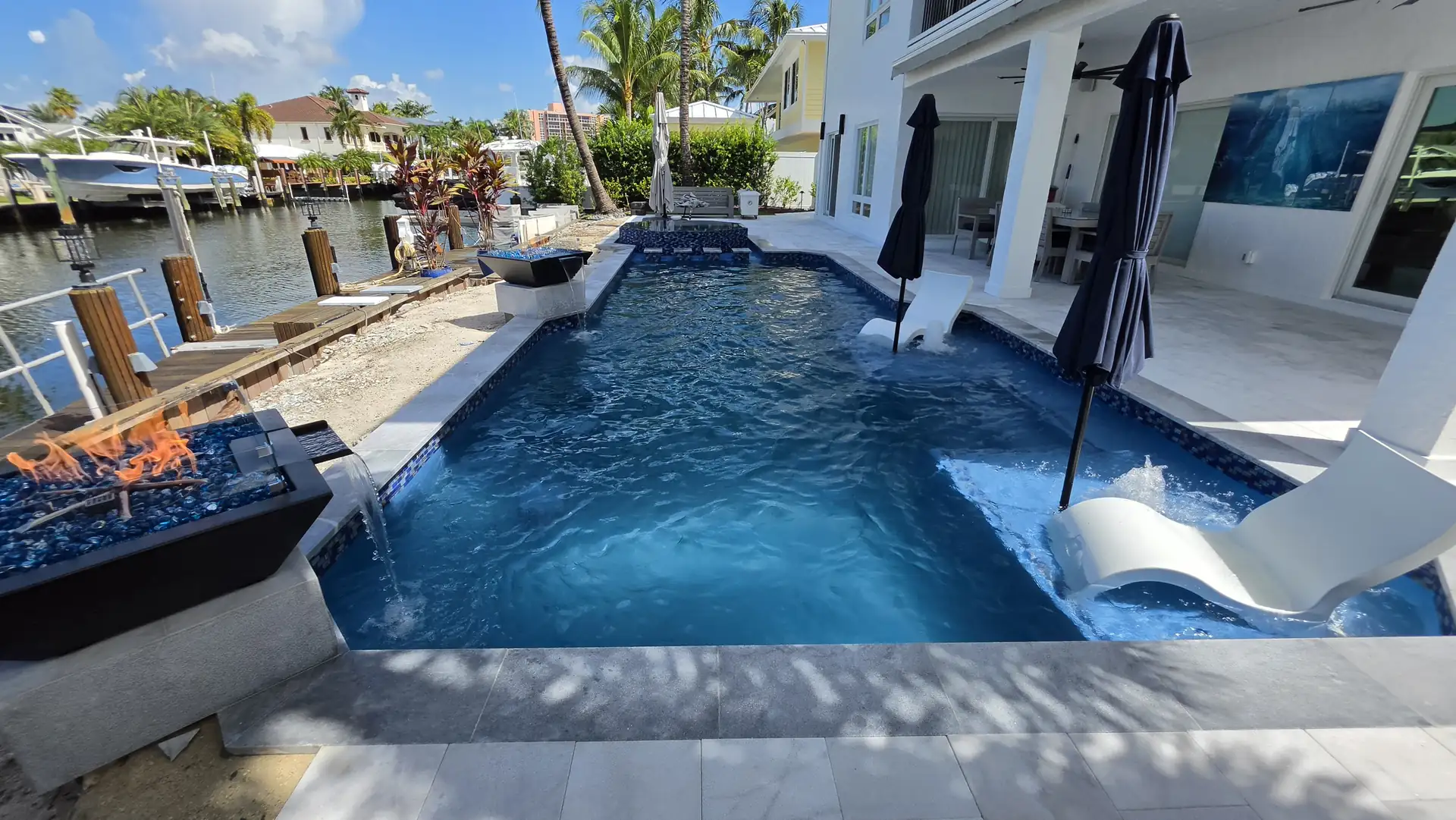 Pool fire bowl framing a private dock and canal view