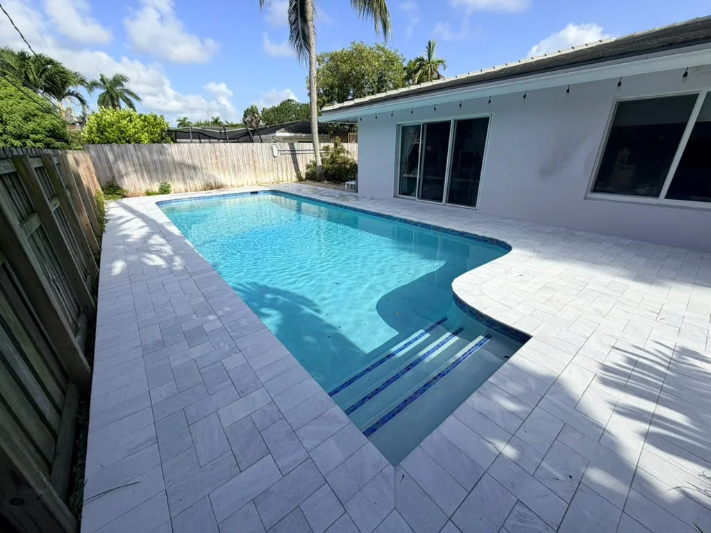 Turquoise pool with wide entry steps and marble pavers
